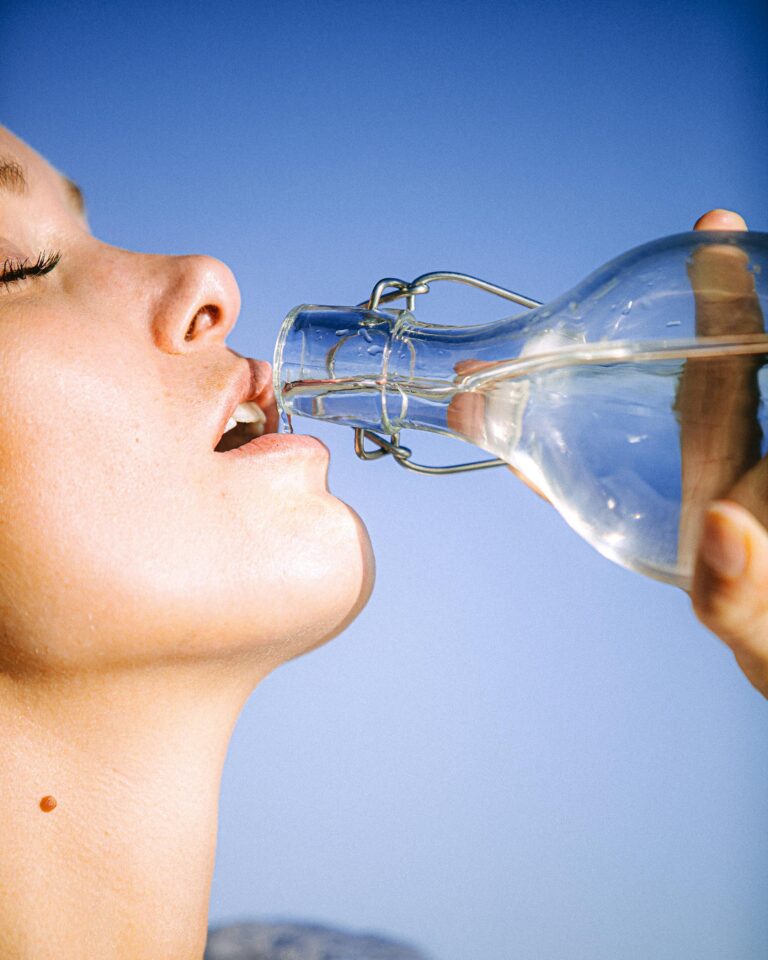 a woman drinking from a bottle